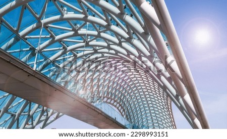The Bridge of Peace is a bow-shaped pedestrian bridge, a steel and glass construction illuminated with numerous LEDs, over the Kura River, linking the Rike Park with Old town in central Tbilisi.