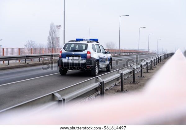 Bridge\
for pedestrians and cars in winter and police\
car