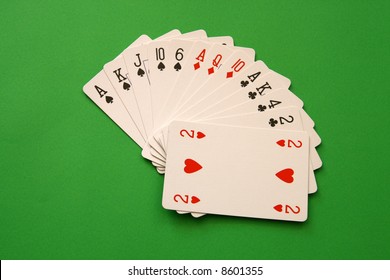 bridge playing - one hand (A,K,J,10,6 spades, 2 heart, A,Q,10 diamonds, A,K,4,2 clubs)  background green,