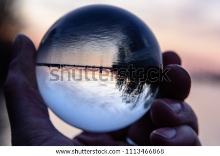 Bridge and Reflection in Crystal Ball during sunset. hand holding chrystal abll