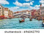 Bridge Rialto on Grand canal famous landmark panoramic view Venice Italy with blue sky white cloud and gondola boat water.