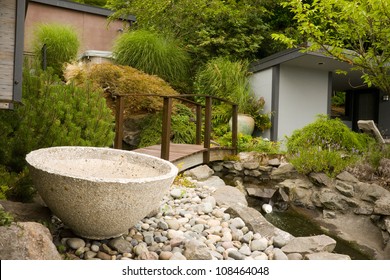 A Bridge Spans Creative Landscaping Water Feature On Home Property