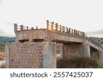 Bridge at sunset, showcasing a crumbling stone and concrete structure. The image highlights nature