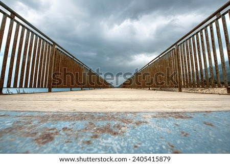 Bridge, vanishing point. Poster design of a pier over the sea, wooden construction like a bridge. Wooden bridge and evening sky.
 
