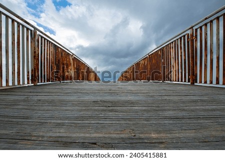 Bridge, vanishing point. Poster design of a pier over the sea, wooden construction like a bridge. Wooden bridge and evening sky.
 
