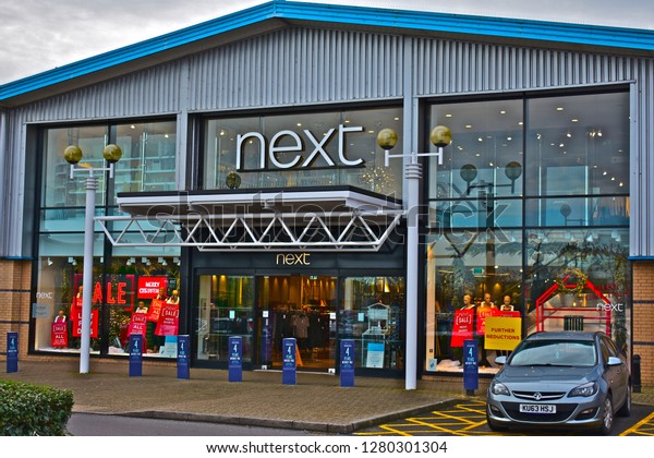 Bridgend, Bridgend County Borough / Wales UK -\
1/8/2019: Front view of Next retail store in Bridgend Retail Park.\
Shop for fashion clothing and accessories. Sale now on. Cars parked\
or passing by.