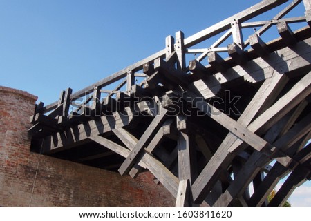 Bridges and crossings. Wooden bridge to a medieval castle. View from below. Use as a symbol of authenticity, reliable support and continuity.