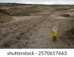 Bridle path, a wooden post with a horseshoe sign that shows the way for horses and their riders in the dunes of Noordwijk aan Zee during the day during winter in the Netherlands with space for text.