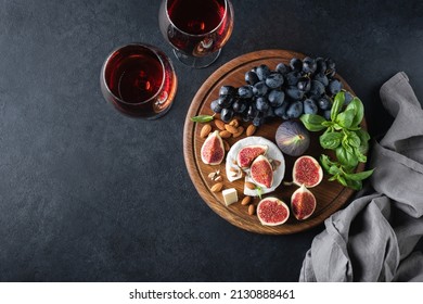 Brie or camembert cheese with grapes and wine. Top view on black concrete table background, copy space - Powered by Shutterstock