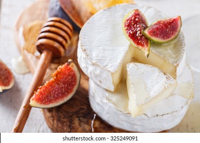Brie cheese on a wooden Board with fresh figs and honey.selective focus. - Shutterstock ID 325249091