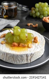 Brie Cheese Served With Grape, Cashew Nuts And Honey On Dark Grey Table, Closeup