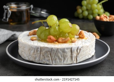 Brie Cheese Served With Grape, Cashew Nuts And Honey On Dark Grey Table, Closeup