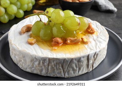 Brie Cheese Served With Grape, Cashew Nuts And Honey On Dark Grey Table, Closeup