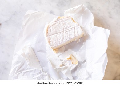 brie cheese in unwrapped packaging on a light background - Shutterstock ID 1321749284