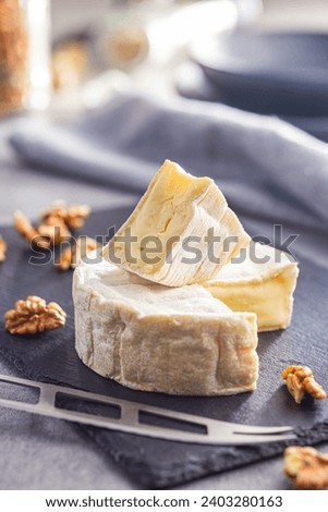 Brie type cheese with white mold. French camembert cheese on the cutting board.