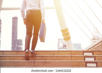 ฺBusinessman with briefcase walks up the stairs. Achievement and success concept.