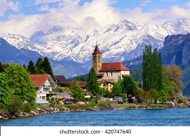 Brienz town on Lake Brienz by Interlaken, Switzerland, with snow covered Alps mountains in background - Shutterstock ID 420747640