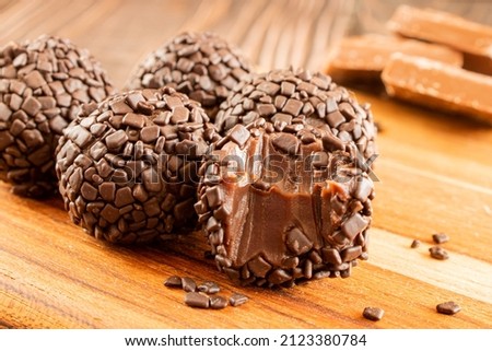 Brigadeiro (Brigadier) Traditional brazilian sweet. Chocolate candy on woody background.