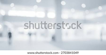 Bright abstract interior background with blurred human figures walking, creating a dynamic ambient scene with glowing soft light that feels modern and active across the space.