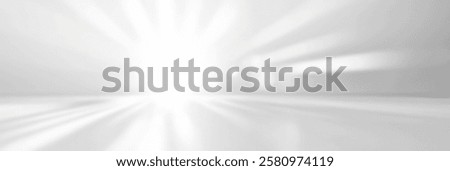 Bright abstract light rays illuminating a soft white background.