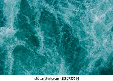 Bright abstract light turquoise background, water with white foam and bubbles