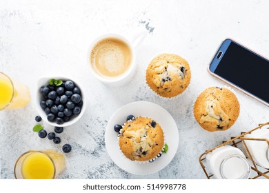 Bright And Airy Breakfast With Blueberry Muffin, Big Cup Of Coffee And Smartphone Overhead View With Copyspace