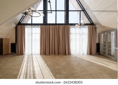 bright attic room with a large triangular window covered by sheer and blackout curtains. Light floods the tiled floor, creating a warm, inviting space - Powered by Shutterstock - Get 15% off with code: PIKWIZARD15