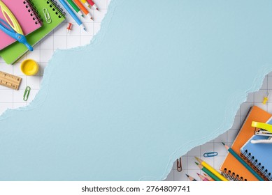 Bright back to school flat lay showing colorful notebook, pencil, scissors, ruler and paperclip arranged around torn blue paper background for education, study, planning and classroom design