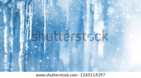 Bright background with icicles. Winter background with icicles and falling shiny snow