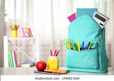 Bright backpack and school stationery on table indoors, space for text