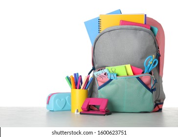 Bright backpack with school stationery on grey stone table against white background - Powered by Shutterstock