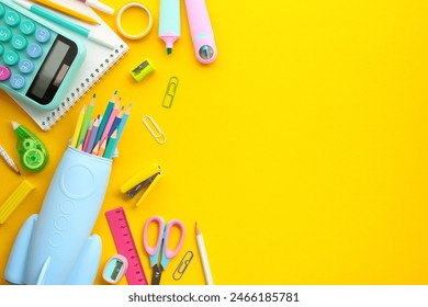 Bright Back-to-School Supplies on Yellow Background. Colorful assortment of educational tools, including calculators, colored pencils, scissors, and rulers, neatly organized on a vivid yellow surface. - Powered by Shutterstock