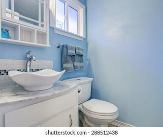 Bright Bathroom With Blue Walls And Marble Counter.