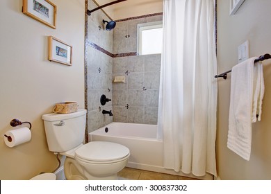 Bright Bathroom With Tile Floor And White Shower Curtain.