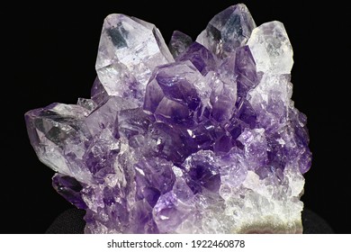 Bright beautiful amethyst druse on a dark background close up. Cluster of lilac crystals