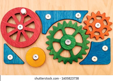 A Lot Of Bright Beautiful Multi-colored Wooden Gears Connected In A Complex Mechanism. Wood Background