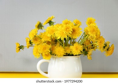 Bright, Beautiful, Yellow Dandelions In White Mug. Spring Or Summer Yellow Flowers On Grey Textured Background. Ultimate Grey. Illuminating. Top View