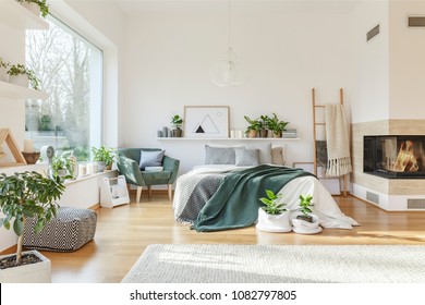 Bright Bedroom Interior With King-size Bed, Rug, Armchair, Fireplace, Window And Ladder