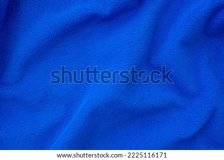 Bright blue fleece cloth. Crumpled, folded blue cloth as background or backdrop, top view