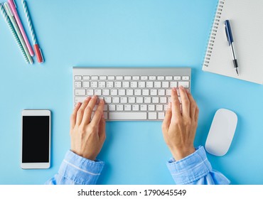 Bright Blue Modern Desk. Top View. Distance Education. Copy Space, Mock Up. Freelancer, Digital Nomad Concept. Keyboard And Mobile Phone On Table