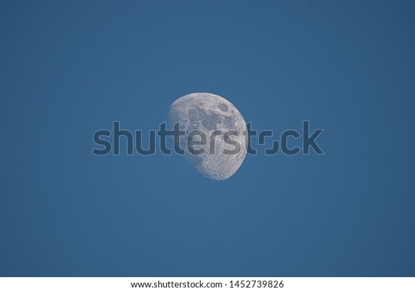 bright blue\
moon in a blue sky with close up\
detail