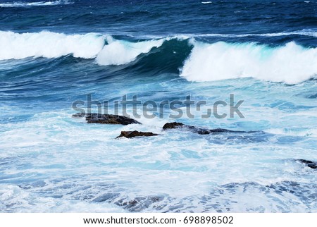 Bright blue ocean waves with whitecaps on a windy day