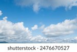 Bright blue skies and calm white clouds are perfect for a serene background or nature design. Vast blue sky with cumulus clouds - serene natural background