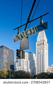 Bright blue sky frames the iconic Metropolitan Life Insurance Tower seen from 5th Avenue in New York City. Nearby buildings add to the urban charm.