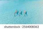 Bright blue waters surround beach loungers in Koh Kood, Thailand. The tropical sun invites relaxation as visitors enjoy a peaceful day in this island paradise. a couple in a hammock in the ocean