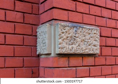 Bright boulders made of sandstone as cornerstones in color contrast to a house wall with wall offset of red brick with small stones and wide, deep joints of the same color made of plaster - Shutterstock ID 1503197717