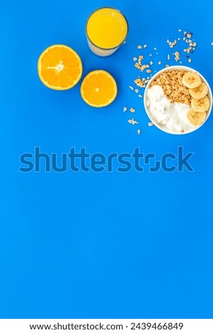 Bright breakfast with granola and orange juice on blue table background top view mockup