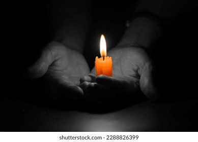 Bright Burning Candle in the Human Hands. Remembrance and Memorial Day Background.