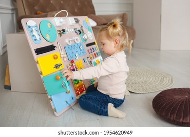 bright Busy board for For children. happy baby playing with busyboard. children's educational toys. Wooden game board. - Shutterstock ID 1954620949
