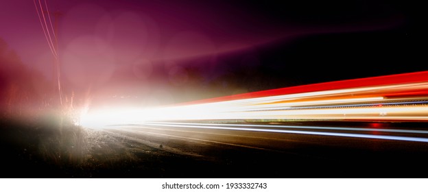 Bright Car Light Trails and Bokeh Effects on Foggy Night Highway. Speed Motion Night Background. Red White Light Beams Traveling from Left to Right.